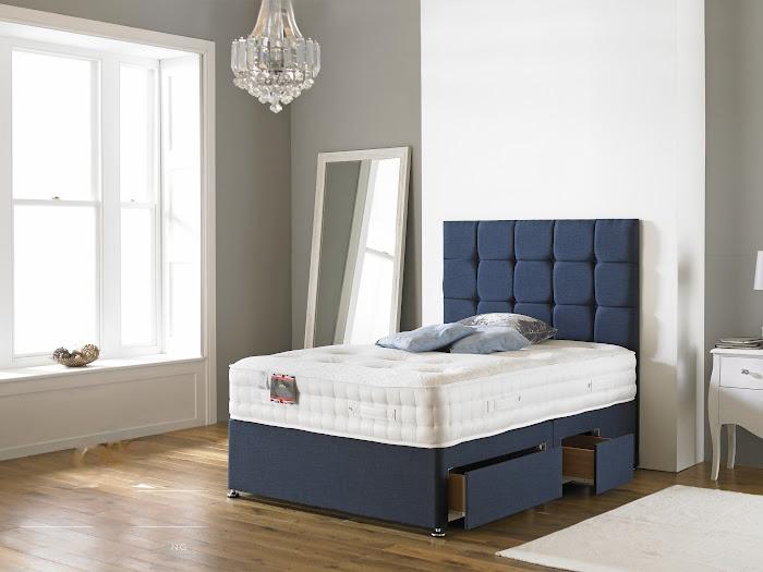 Bed with cube headboard in a room with a window and mirror.